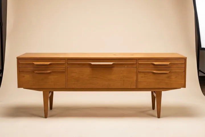 A Danish teak sideboard photographed straight on against warm paper