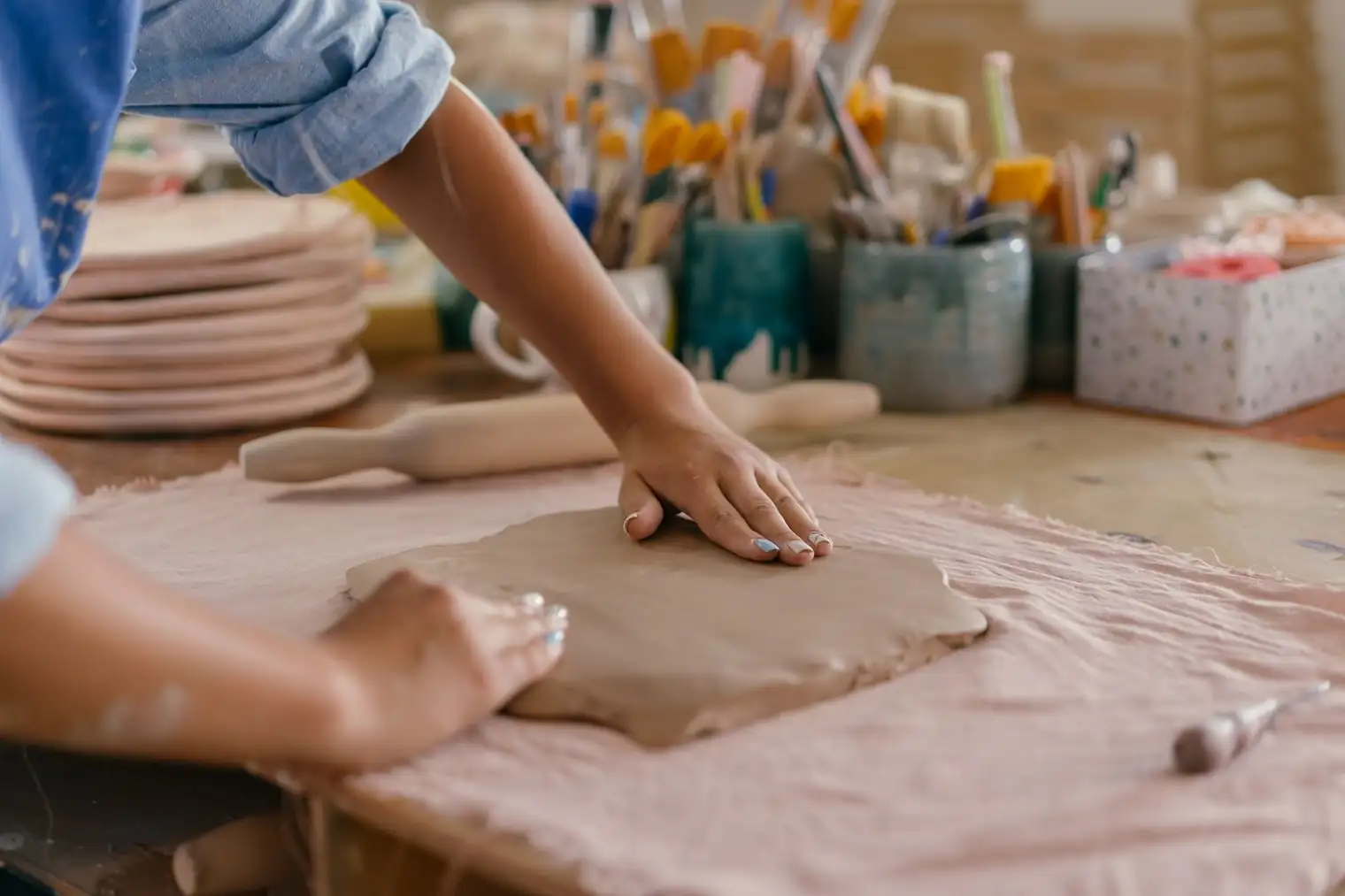Two hands turning a ceramic bowl over to inspect the foot ring